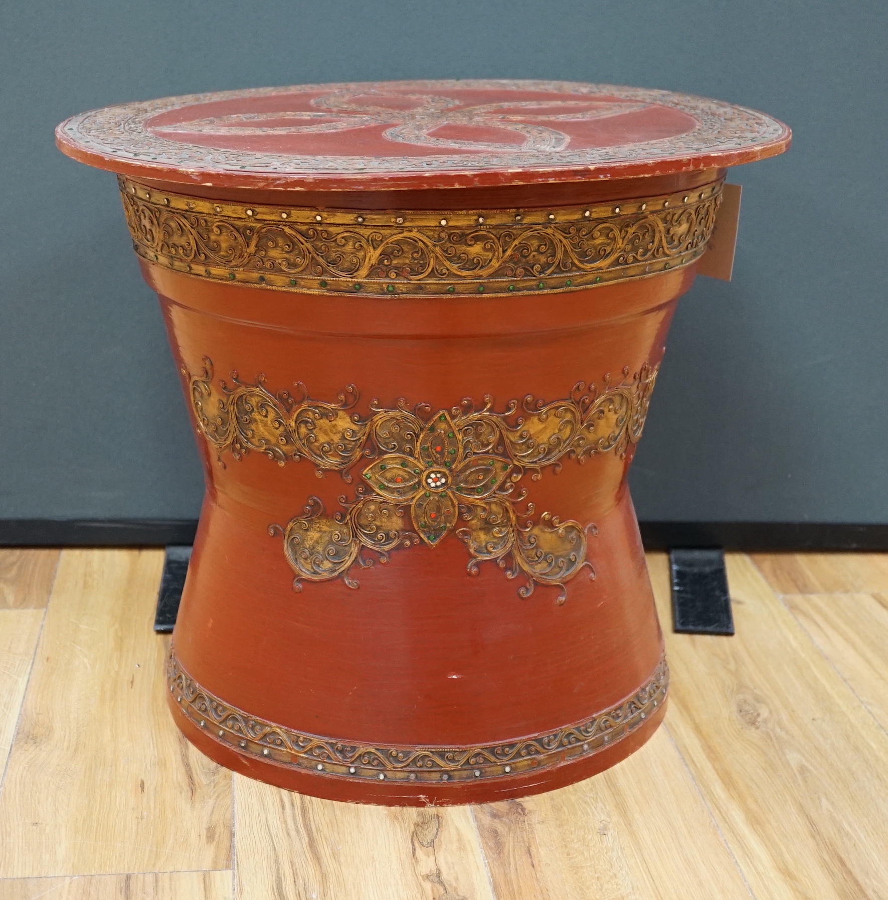 A South East Asian composition red lacquered table inset mirrored sequins, 44cm high x 51cm in diameter